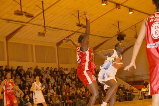 Jeanne Senghor (rouge-UST) défendant sur Sylva (en blanc - basket Landes) sous le regard de Balayara